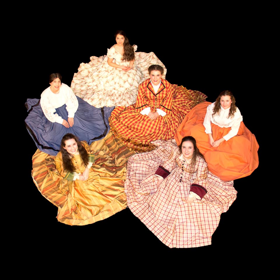 The March sisters and company gather in a flower-like circle of 1860s gowns, shot from above — Little Women, spring 2014.
