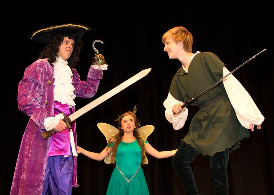 Captain Hook and Peter Pan square off, swords drawn, as a winged Tinker Bell joins their hands — Peter Pan, fall 2013.